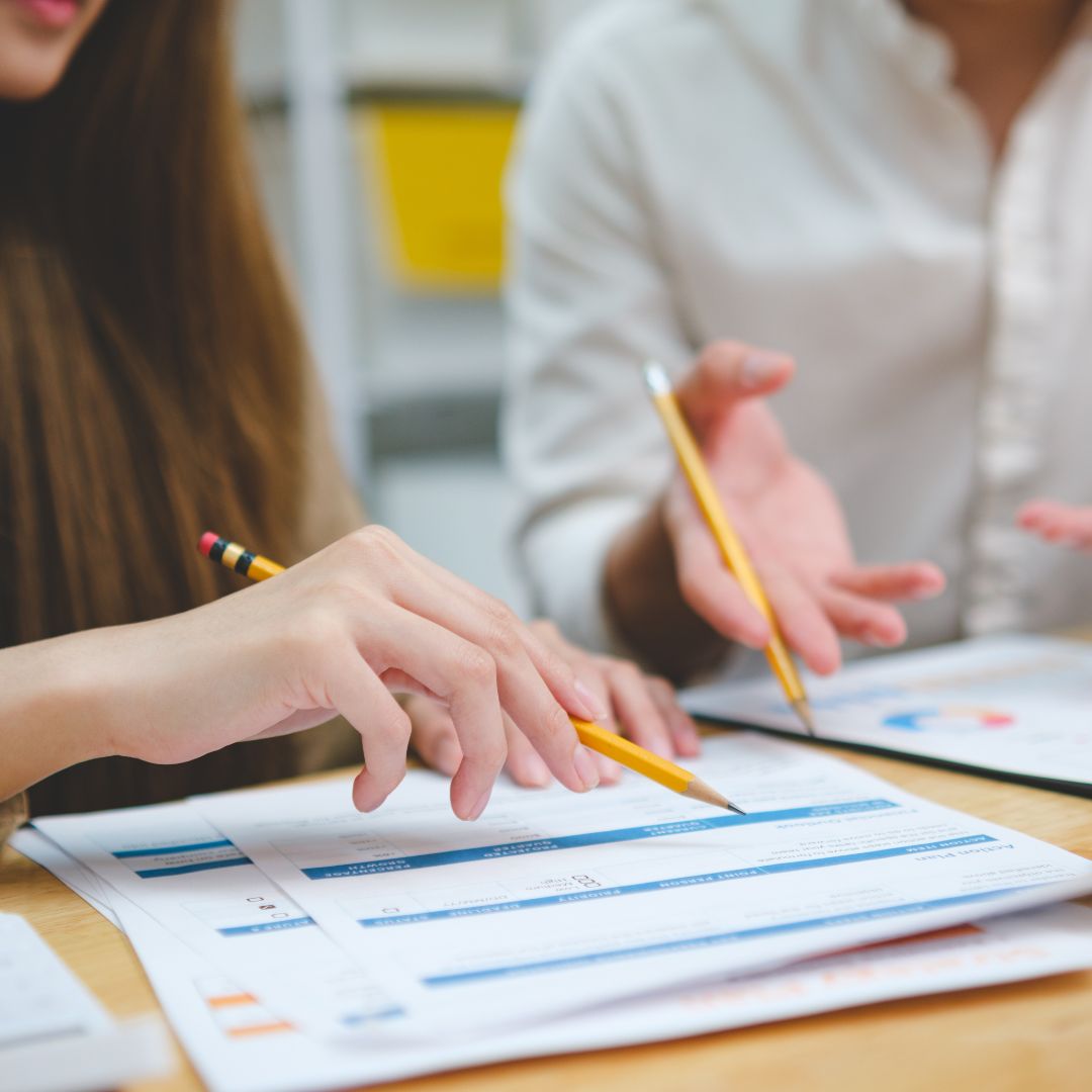 A group of young adults laughing and enjoying time together outdoors under the sun.
